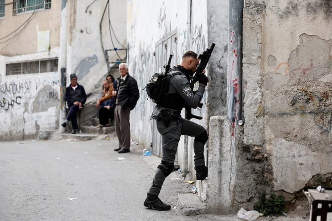 イスラエルが1967年の中東戦争後にエルサレムに併合した占領地にあるネヴェ・ヤアコフのシナゴーグ付近でカイレ・アルカムが少なくとも7人を射殺した後、東エルサレムのア・トゥールのパレスチナ人銃撃犯アルカムの家に向かって歩くイスラエル国境警察官（2023年1月28日）。(ロイター)