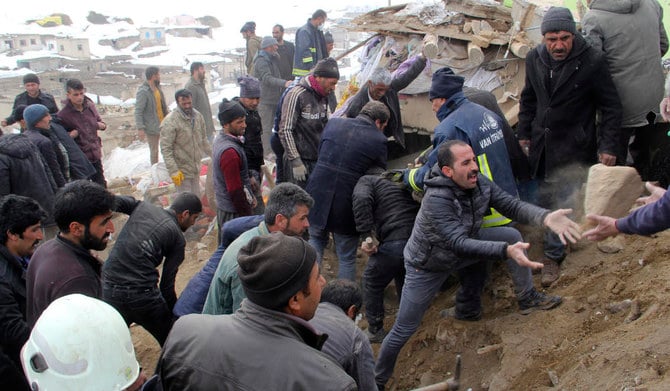 2020年2月23日（日）、イランとの国境沿いにあるトルコのヴァン県の村バシュカレを地震が襲った後、人々が瓦礫を取り除き、倒壊した家屋の下に閉じ込められた人々を助けようとしている。（AP）
