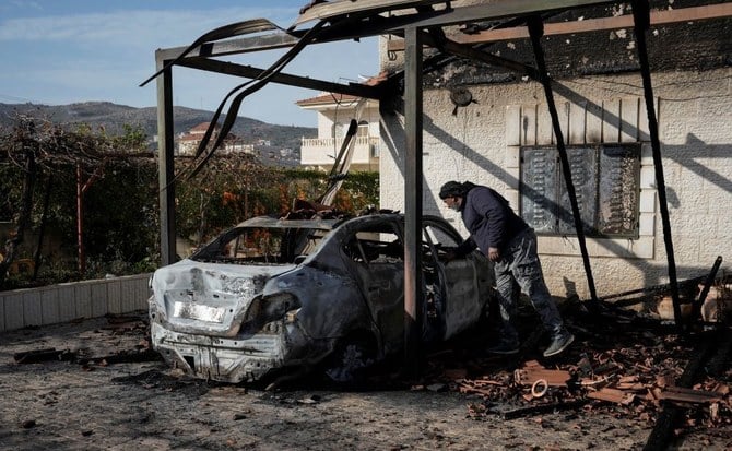 ヨルダン川西岸地区の都市ラマッラーに近いタルムサヤの村で、ユダヤ人入植者が火を放って燃えた車を調べるパレスチナ人男性。2023年1月29日（AP Photo）