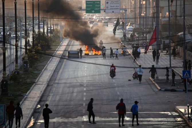 治安部隊との衝突でデモ隊メンバーが死亡したことをめぐり、抗議として道路を封鎖するイラク国民ら＝2022年12月11日、イラク南部・ナシリヤ市（写真：AFP）