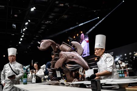 フランス南東部リヨン近郊のシャッシューエクスポ会場で開催されたSIRHA(Salon International de la Restauration, de l'Hôtellerie et de l'Alimentation)で2023年ボキューズ・ドール・パティスリー・コンクールに出場し、作品の準備をする日本チームの高橋萌氏(右)。 2023年1月21日 (AFP)