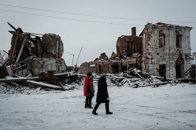 ハルキウで破壊された建物の前を歩く人々。2月24日、ロシア・ウクライナ戦争は開始から1年を迎える(File/AFP)