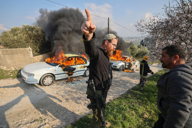 入植者らが車に放火した後に発生したパレスチナ人らとの間の衝突の最中、身振りを交える武装したイスラエル人。2023年2月25日、ブリン村。（AFP）
