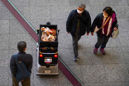 2023年1月13日撮影、東京駅に近い丸の内のショッピング・ビジネス街で、温かい飲み物とスナックを販売するパナソニックの配達ロボット「ハコボ」。(AFP)