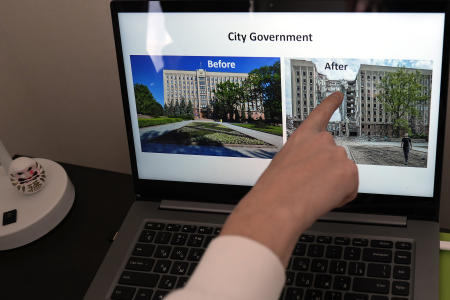 東京でAP通信のインタビューに応じ、寮の部屋でPC画面上の市庁舎の被害状況を示す画像を指差すレメズさん。2023年2月15日。(AP)