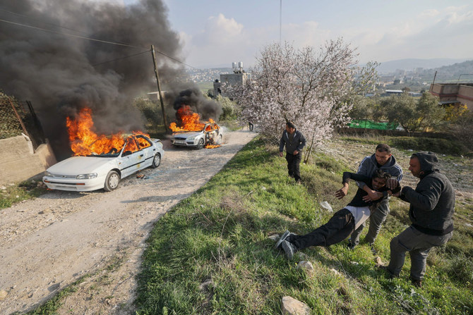 近くのブラハ入植地から来たイスラエル人入植者らが車に放火した後に発生した衝突の最中に負傷した若者を運ぶパレスチナ人ら。2023年2月25日、ヨルダン川西岸地区のブリン村。（AFP）