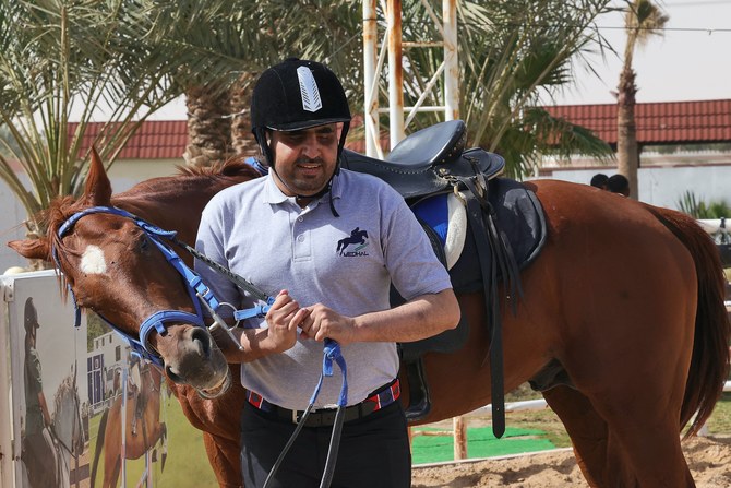 リヤド東部にあるメダル乗馬センターでのトレーニングセッションで馬を先導する、サウジアラビアの盲目の騎手バドル・アル・シャラリ氏。AFP