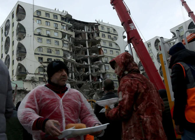 2023年2月6日、トルコのディヤルバクルで発生した地震で被害を建物の近くで、食料を受け取るために待っている人々。（ロイター）