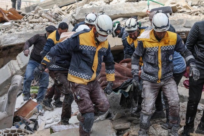 地震発生後、建物の瓦礫の中から犠牲者を運ぶシリア民間防衛隊（通称ホワイトヘルメッツ）のメンバーたち。2023年2月7日、トルコとの国境近く、反体制派が掌握するシリア北西部のイドリブ県のアズマリン村。（AFP）