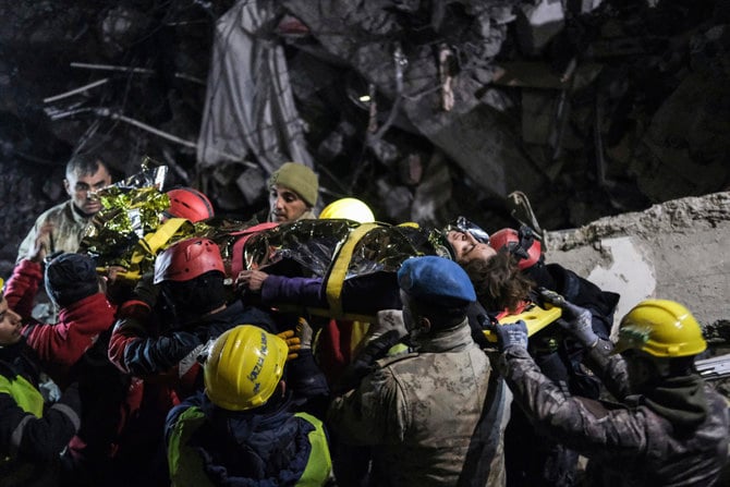 月曜日の地震から数日経過した後に救出されたセナ・ナノ氏（67歳）を救急車に運ぶ救助隊員たち。トルコ南部カフラマンマラシュ、2023年2月11日。（イスマイル・コスクン / IHA、AP通信経由）  