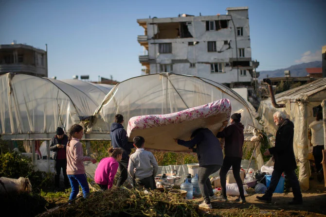 震災後の避難先となった温室に、マットレスを持ち込む地元住民（2023年2月16日木曜日、トルコ南部のサマンダーにて）。（AP）