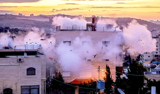 煙が吹き出している。緊張が高まる中、占領地ヨルダン川西岸地区ヘブロンで16日、イスラエル治安部隊がパレスチナ人の家を取り壊した。（AFP）