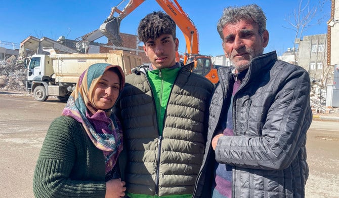 トルコ・シリア地震でタハ・エルデムさんが閉じ込められた倒壊した建物のそばで、写真撮影するタハ・エルデムさん（中央）、母親のゼリハ・エルデム氏（左）、父親のアリ・エルデム氏＝2023年2月17日撮影、トルコ・アディヤマン）。（AP）