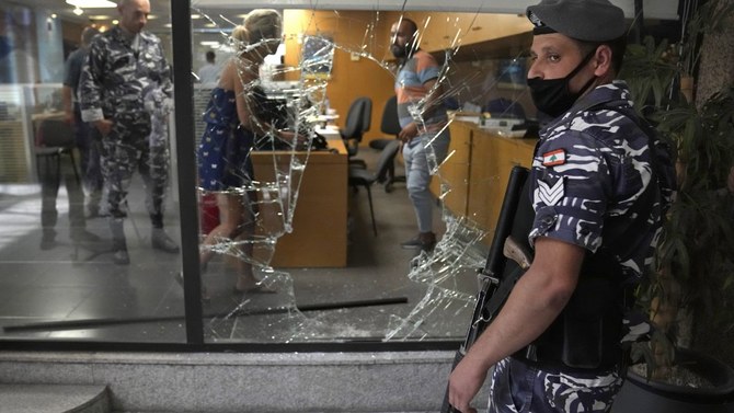 預金者に割られた銀行の窓の横で警備する警察官（2022年9月14日、レバノン・ベイルート）。（AP写真）
