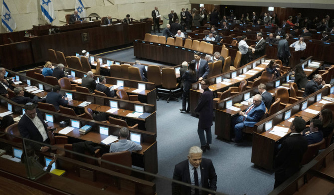 クネセト（イスラエル国会）の議場を歩くヤイール・ラピード議員（手前）。2023年2月20日（月）、エルサレムで、イスラエルの法体系を見直す計画の採決に向けて議員が招集された。（AP）