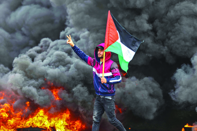 パレスチナの若者がタイヤを燃やしている。イスラエルとガザの境界の近く、ジャバリア難民キャンプの東で先日、抗議デモが行われた。（AFP）