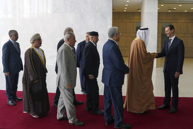 アラブの様々な国の代表者を迎えるシリアのバッシャール・アサド大統領（右。2023年2月26日）。（AP経由SANA）