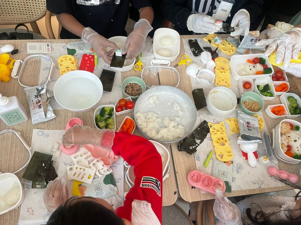 おむすび作りに合わせ、子供たちには、野菜を切ったり、おにぎりの型を作ったり、ごはんの型を作ったり、お弁当箱を飾ったりするのに役立つ道具がいくつか手渡された。(ANJ Photo)
