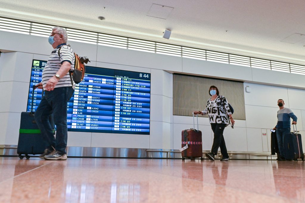 乗客たちが東京の羽田空港国際線ターミナルに到着する。（AFP）