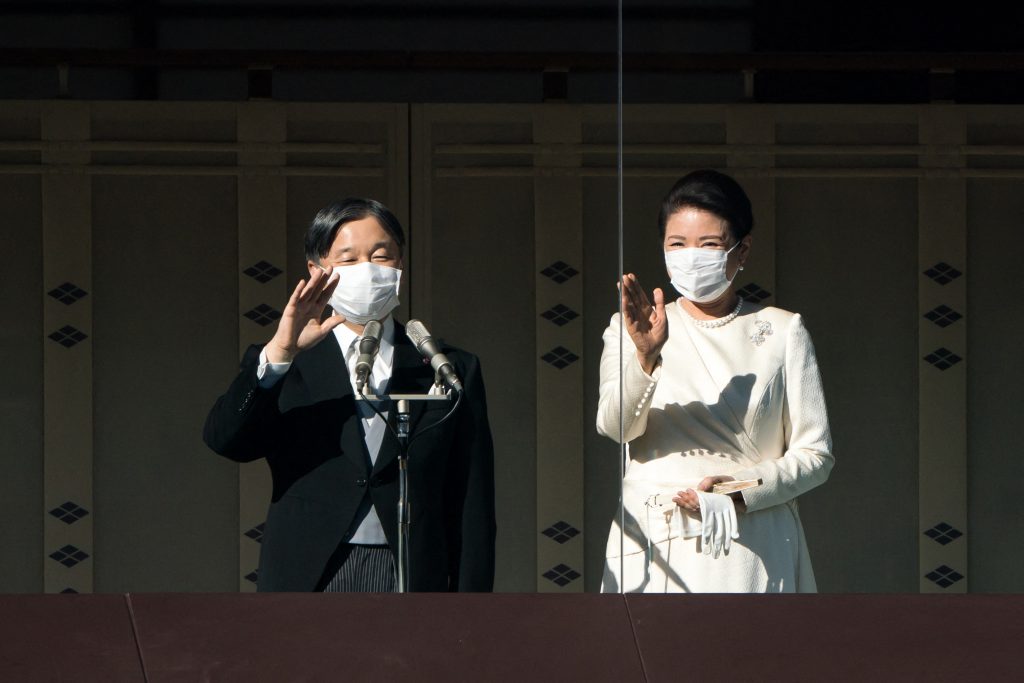 皇族による「新年祝賀の儀」で天皇陛下(写真左)と皇后陛下(同右)が手を振っている。2023年1月2日、東京の皇居で撮影。(AFP通信)