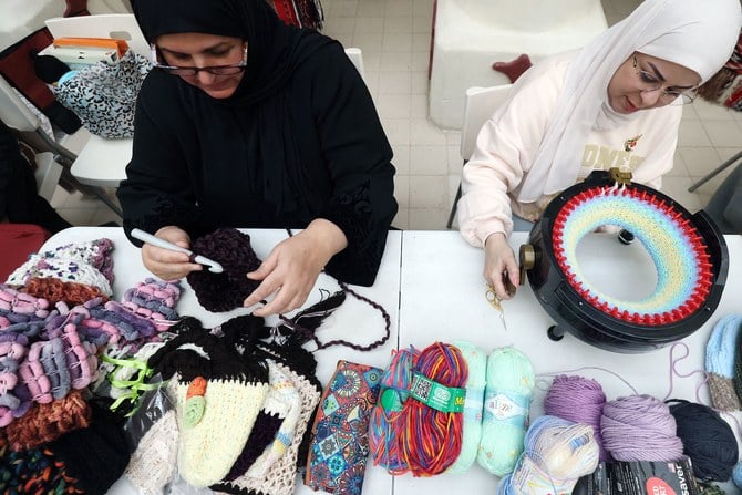 2023年2月11日クウェート市にて、トルコとシリアを襲った大地震の被災者に送るために、暖かいマフラーと帽子を作るクウェートの女性たち。(AFP)