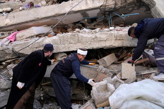 2023 年 2 月 7 日、トルコ南部のイスケンデルンの町で、破壊された建物の瓦礫の中から生存者を捜す人々と緊急チーム。 (AP)