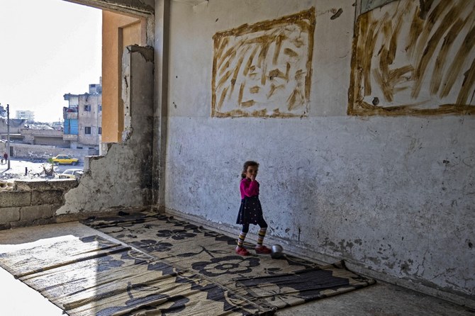 シリアの反政府勢力が支配する北部の都市ラッカで撮影された、戦災で破壊された建物で暮らすシリアの避難民の子ども。（AFP通信）