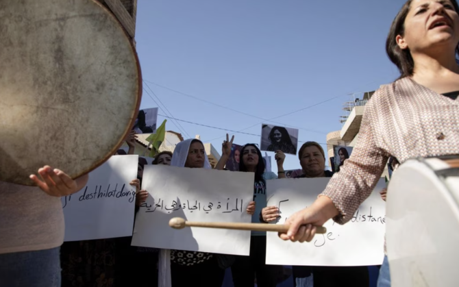 イランで22歳のクルド人女性マフサ・アミニさんの死に対する抗議活動で横断幕を持ち、楽器を演奏する女性たち。（Reuters/File Photo）