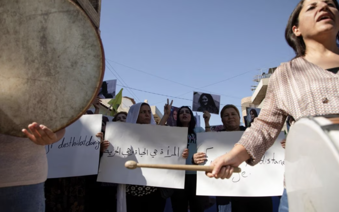 イランで22歳のクルド人女性マフサ・アミニさんの死に対する抗議活動で横断幕を持ち、楽器を演奏する女性たち。(Reuters/File Photo)