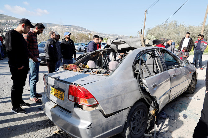破損した車を見る人たち。ジェニンの近くでイスラエル軍が作戦を実行し、パレスチナ武装組織のメンバー3人を殺害した。（ロイター）