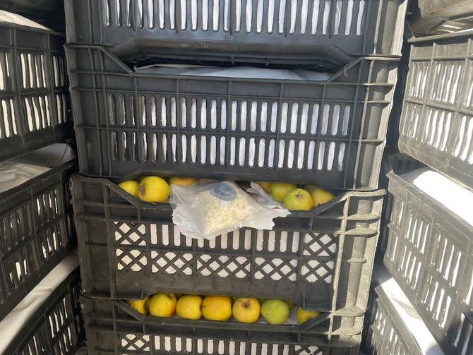 シリアとイラクを結ぶアル・カーイムの国境検問所で、リンゴの木箱に隠されたカプタゴン錠がイラク当局に押収された。（イラク国境当局/AFP）