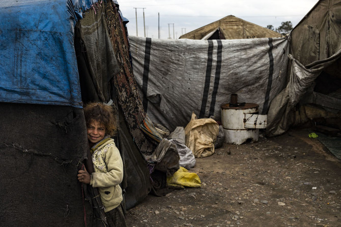  シリア北部ラッカの郊外にある国内避難民のためのSahlat al-Banatキャンプ内で、テントの入り口に立つ子ども。（AFP）