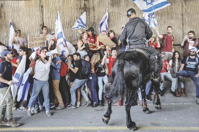 16日、物議を醸しているイスラエルの司法改革案に反対するテルアビブのデモ隊と対峙する馬に乗った警察官。（AFP）