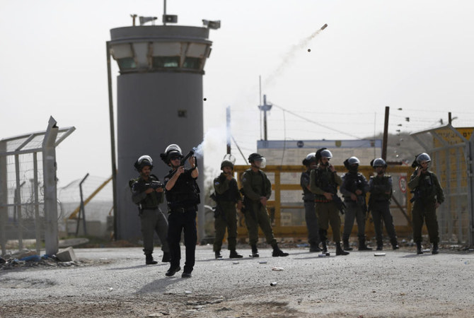 ヨルダン川西岸地区の町ベトゥニア近く、イスラエルのオフェル軍刑務所敷地周辺でパレスチナの大学生と衝突し催涙ガスを発射するイスラエル治安部隊。（AFP）