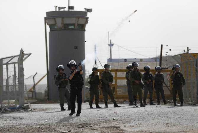 ヨルダン川西岸地区の町ベトゥニア近く、イスラエルのオフェル軍刑務所敷地周辺でパレスチナの大学生と衝突し催涙ガスを発射するイスラエル治安部隊。(AFP)