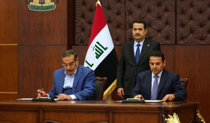 2023年3月19日にバグダッドで行われた、イラン最高国家安全保障会議のアリ・シャムハニ書記（左） とイラク国家安全保障顧問のカセム・アル・アラジ氏（右） による安全保障協定の署名式に出席する、イラクのムハンマド・シア・スダニ首相（中央） 。（AFP）