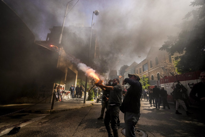 3月24日、ベイルートのレバノン中央銀行ビルで花火を発射するデモ参加者。（AP）