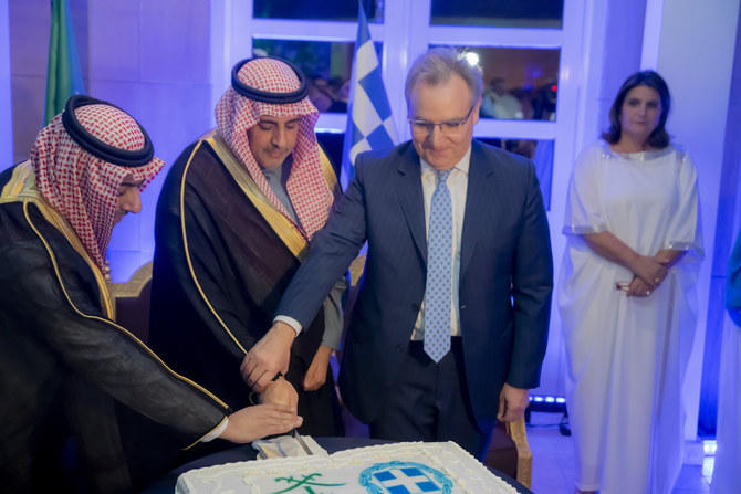 サウジアラビアのギリシャ大使アレクシス・コンスタントプロス氏が、独立記念日の祝賀式典でリヤド地域の次官ファイサル・アル・スダイリ氏とケーキカットをする。（サウジアラビアのギリシャ大使館）