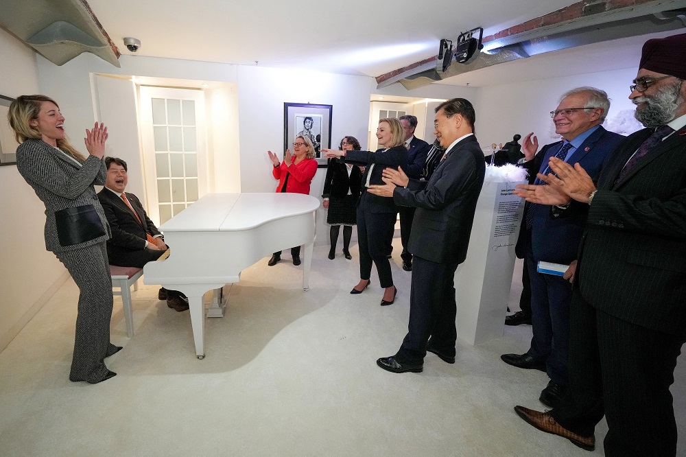 G7外相・開発相会合1日目終了後にビートルズ・ストーリー博物館を訪れた際、ジョン・レノンのピアノのレプリカで「イマジン」を弾いて他の外相らから拍手を受ける日本の林芳正外相（左から2番目）。2021年12月11日、リバプール（AFP）