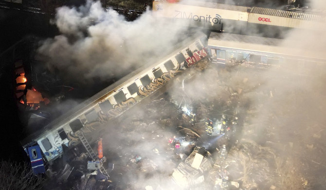 ギリシャのラリサ近郊で発生した衝突事故の後、消防士や救助隊が出動する中、列車から煙が立ち上っている。2023年3月1日（水）未明撮影。（AP）