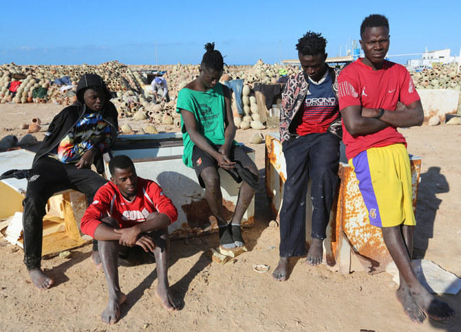 チュニジアの国家警備隊が沈没船から救出された後、リビアとの国境に近いベンゲルダンのエルケテフ港のビーチで休憩する移民（2021年12月15日撮影）。（ファイル／AFP）