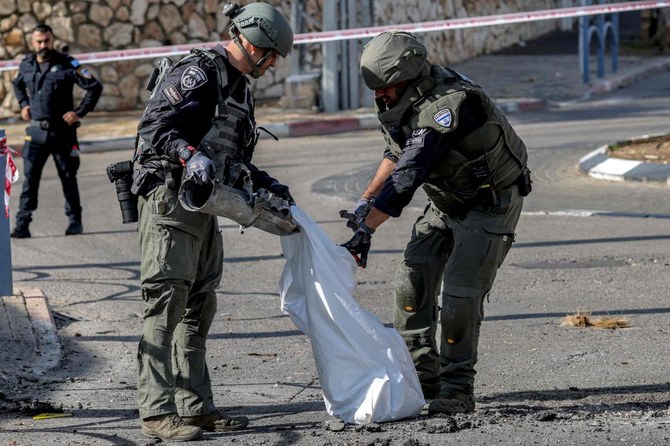イスラエル警察の爆弾処理班員が、レバノンから発射されイスラエルによって迎撃された砲弾の破片を袋に入れている。イスラエル北部の町シュロミにて、2023年4月6日。（AFP）