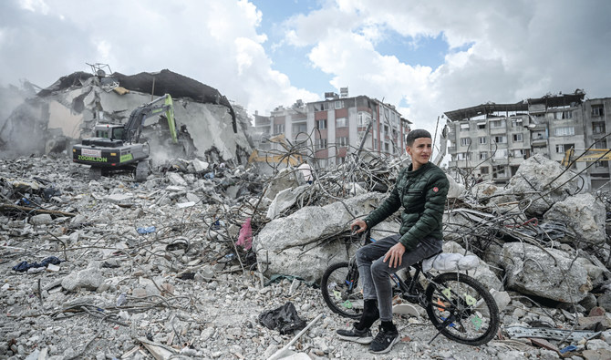 地震に見舞われたトルコ南東部の山に囲まれたアンタキヤで、自宅のがれきが取り除かれるなか、私物を探す若い住人。(AFP)