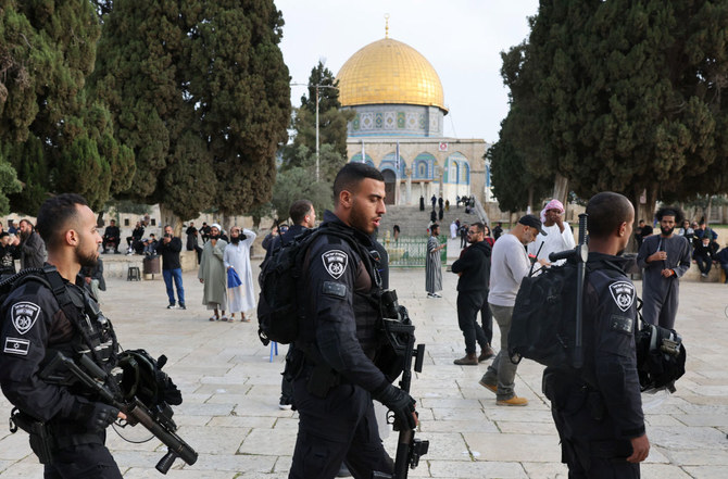 イスラム教の聖なる断食月ラマダンとユダヤ教の過越の祭がぶつかった2023年4月9日、エルサレムにあるアル・アクサモスクの敷地内（ユダヤ人の間では神殿の丘として知られる場所）を、イスラエルの治安部隊に守られながら歩くユダヤ人たち。（AFP）