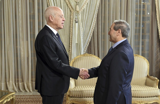 握手を交わすチュニジアのカイス・サイード大統領（左）とシリアのファイサル・メクダド外相。4月18日、チュニジアの首都チュニス近郊のカルタゴにて。（チュニジア大統領府による提供写真）。（AP）