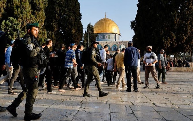 エルサレム旧市街のアル・アクサモスク敷地内で、入植者の隣を歩くイスラエル治安部隊の隊員たち＝2023年4月5日。（ロイター）