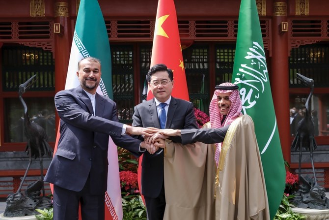 6日、北京で握手するサウジ、イラン、中国の外相。（AP経由新華社通信）