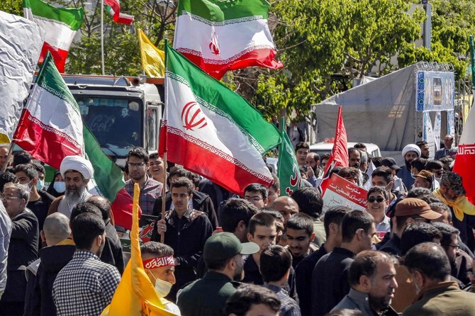 毎年ラマダンの最終金曜に開催される記念日、アル＝コッズの日（エルサレムの日）を祝う集会でイラン国旗やプラカードを持ち練り歩く人々。（AFP）