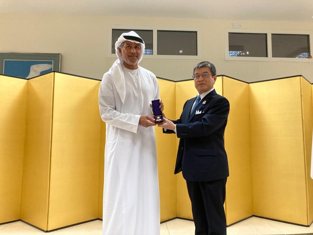 UAE柔道連盟のナセル・アル・タミミー事務局長に旭日双光章を授与する磯俣秋男駐アラブ首長国連邦大使、アブダビの日本大使公邸にて。（提供）
