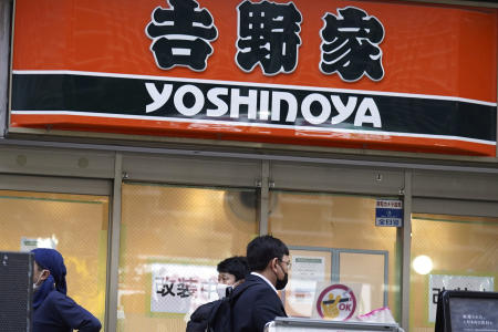 ファストフードの牛丼チェーン店「吉野家」の看板。2023年4月5日(水) 東京都内。日本の警察は、西日本の有名な牛丼店で、共用の容器から直接箸で薬味の生姜を口に押し込んだ疑いで、男2人を逮捕した。これは、以前から寿司チェーンを襲い、「寿司テロ」として知られていた一連の食のいたずらの最新のものである。(AP 写真/ユージーン・ホシコ)
